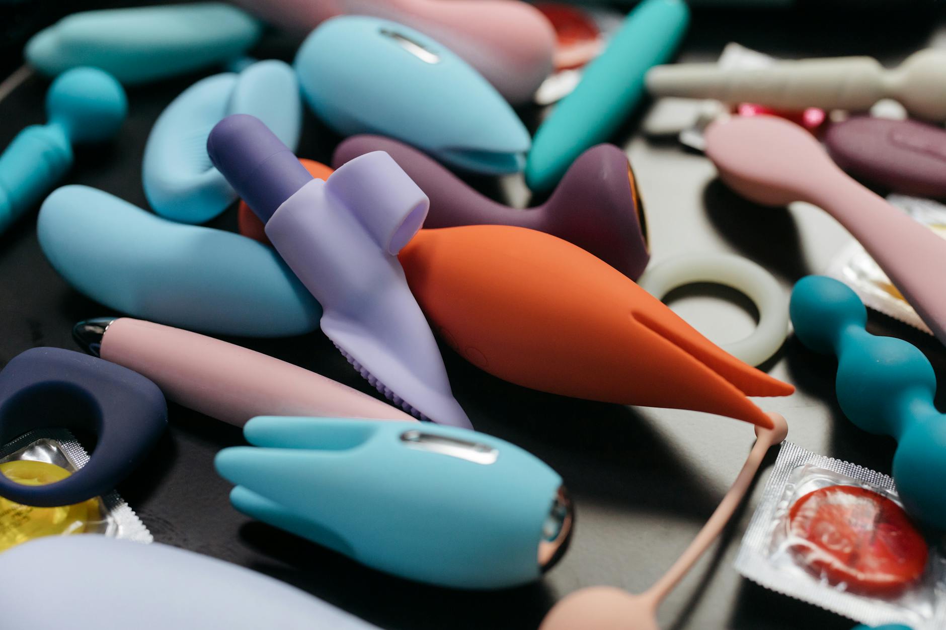 An array of vibrant adult toys including colorful clitoral vibrators in a close-up view