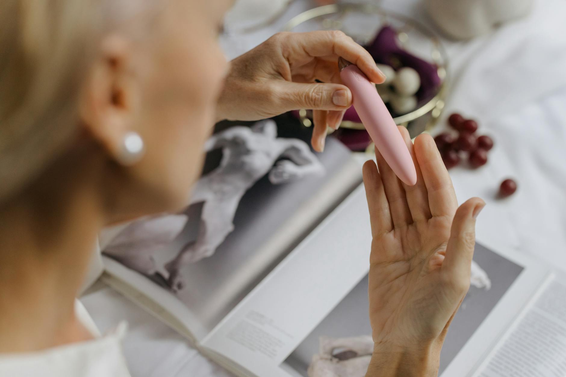 Close-up of a woman holding a pink vibrator, emphasizing personal reconnection and intimate self-discovery