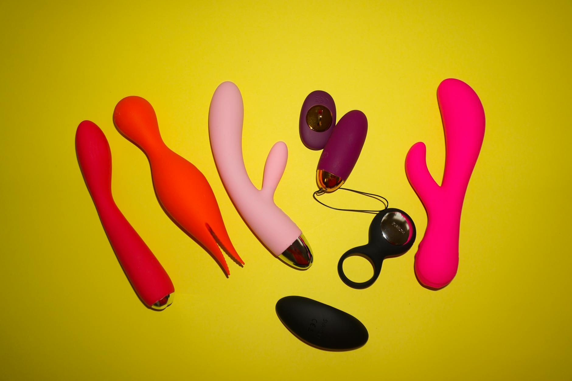 Hands holding a sleek vibrator against a purple background, representing intimate body reconnection